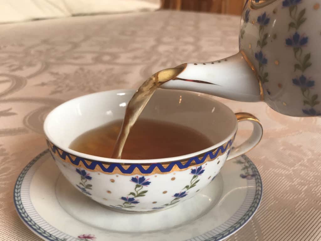 tea pouring into a china teacup