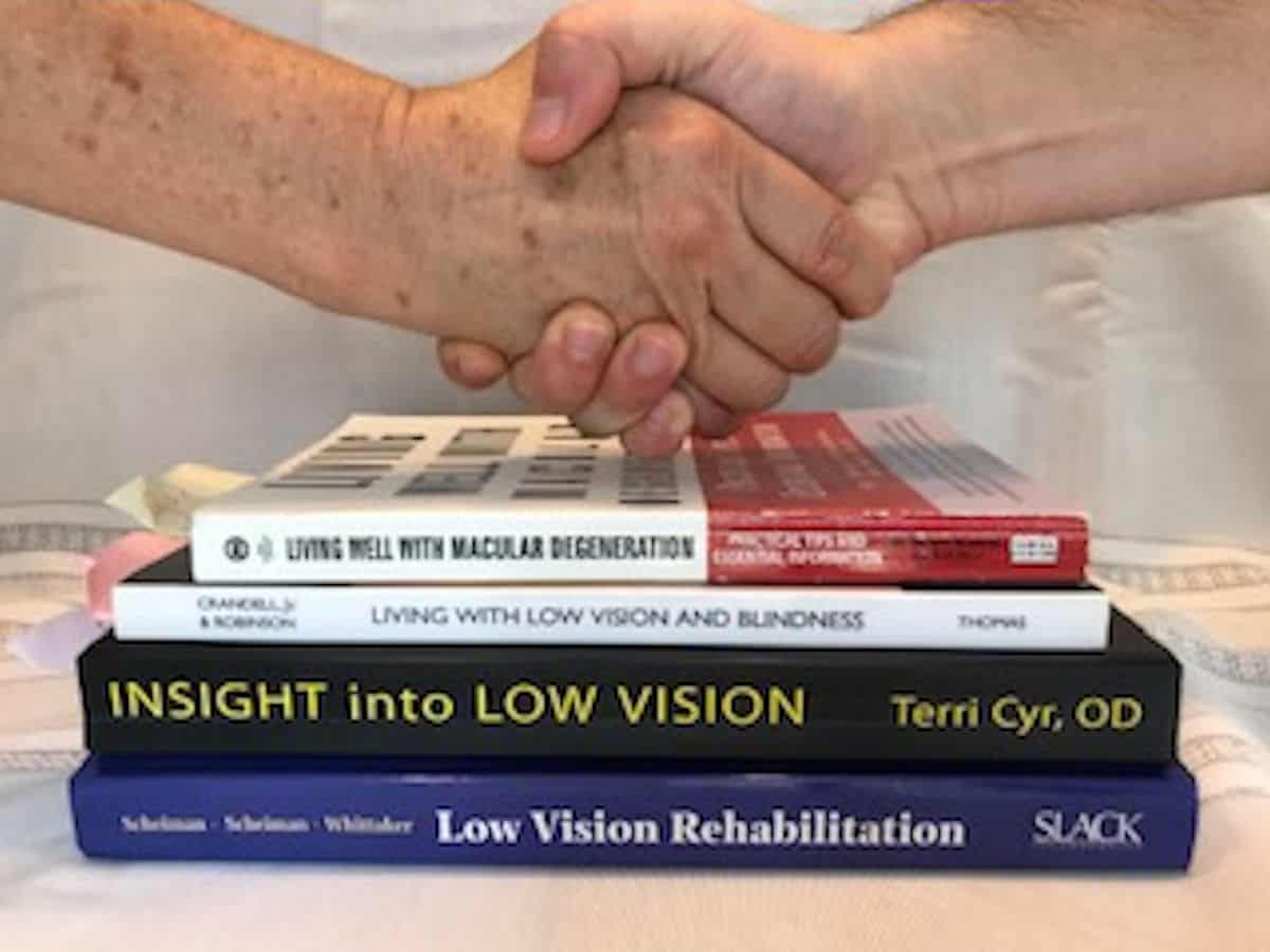 photo of hands shaking overbooks for low vision rehabilitatin
