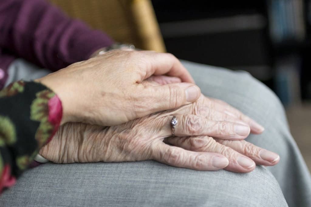 photo of a younger hand holding an older persons hand