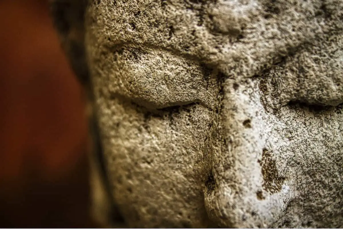 photo of the closed eyes of an ancient statue