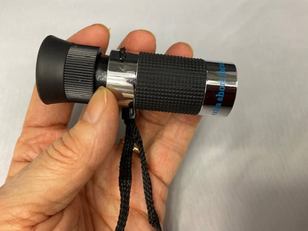 hwnd holding a monocular telescope