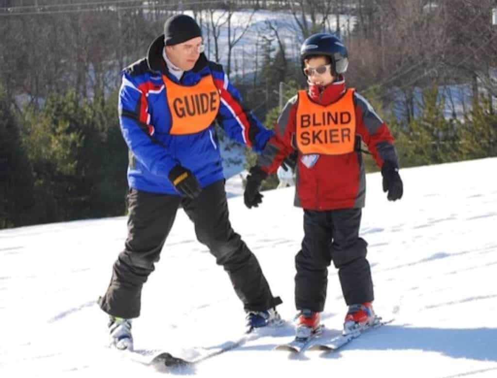 Child and adult guide on the ski slope